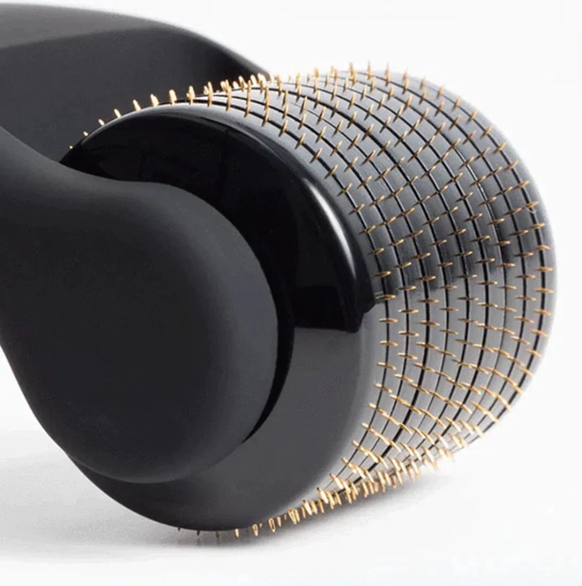 Close-up van een zwarte dermaroller met fijne gouden naaldjes, beauty product.