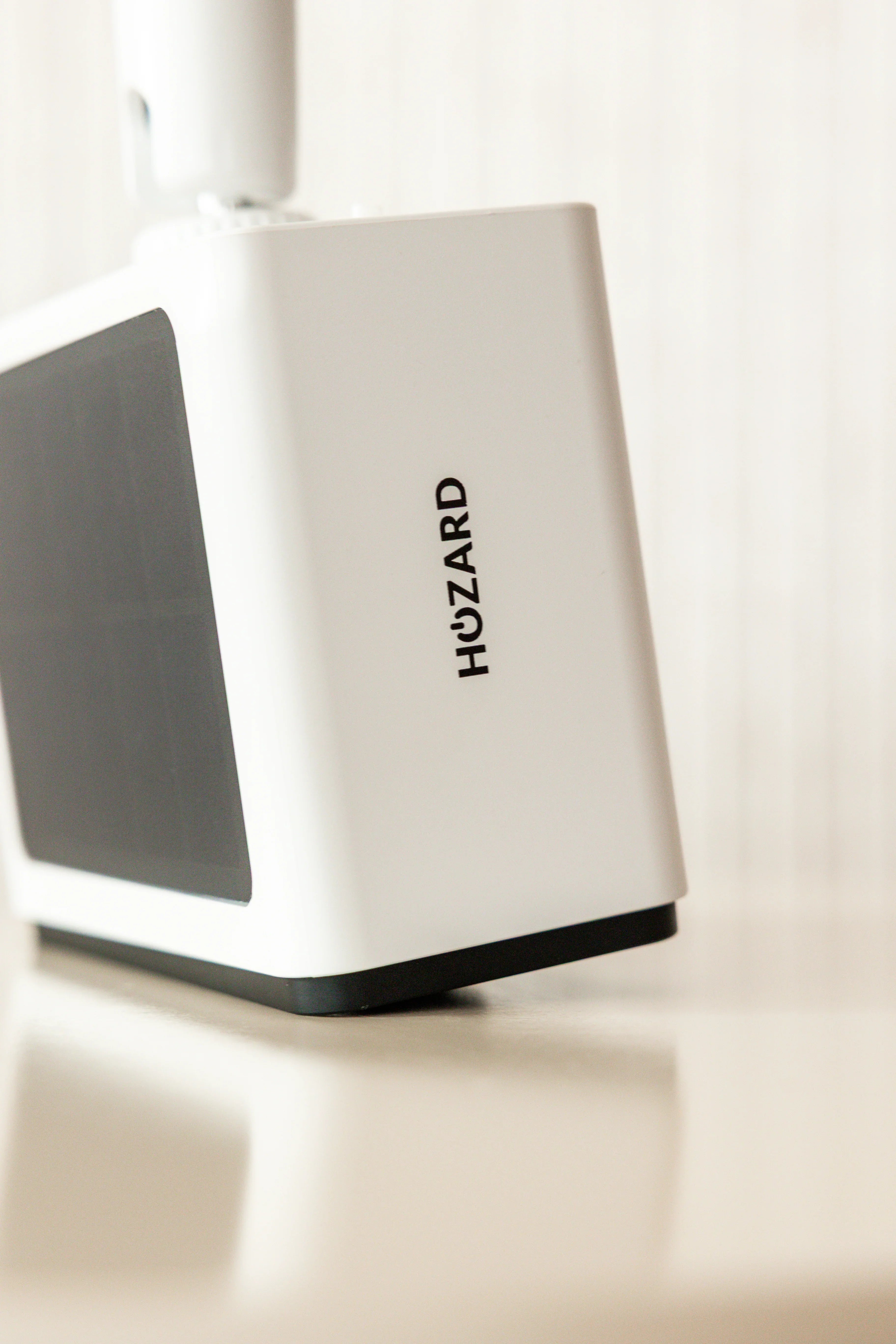 Witte beveiligingscamera met zwart zonnepaneel en Hozard logo, moderne elektronische gadget