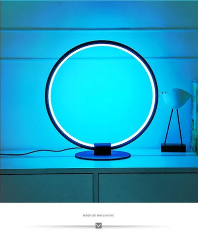 Moderne ronde led tafellamp met blauw licht op een kast, minimalistische sfeer.